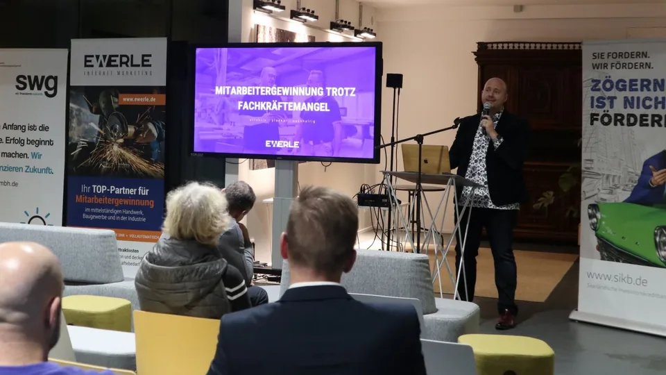 Frank Ewerle spricht beim SIKB-Netzwerktreffen im Halle4 Coworking Space – auf dem Bildschirm der Vortragstitel „Mitarbeitergewinnung trotz Fachkräftemangel"
