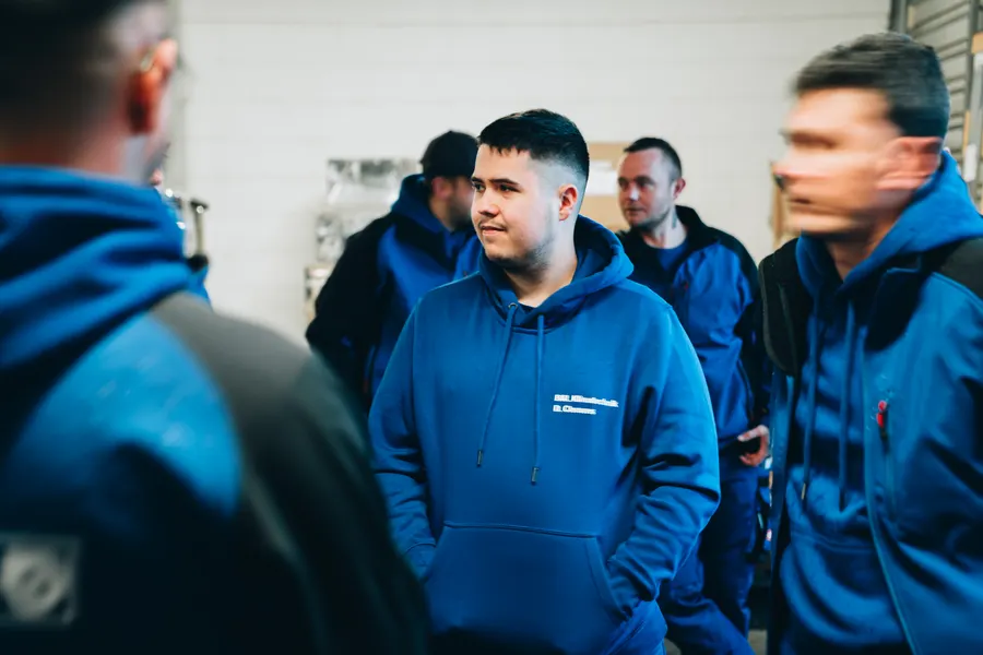 Professionelle Betriebsfotografie: junger Mitarbeiter im Team eines Klima- und Lufttechnik-Betriebs
